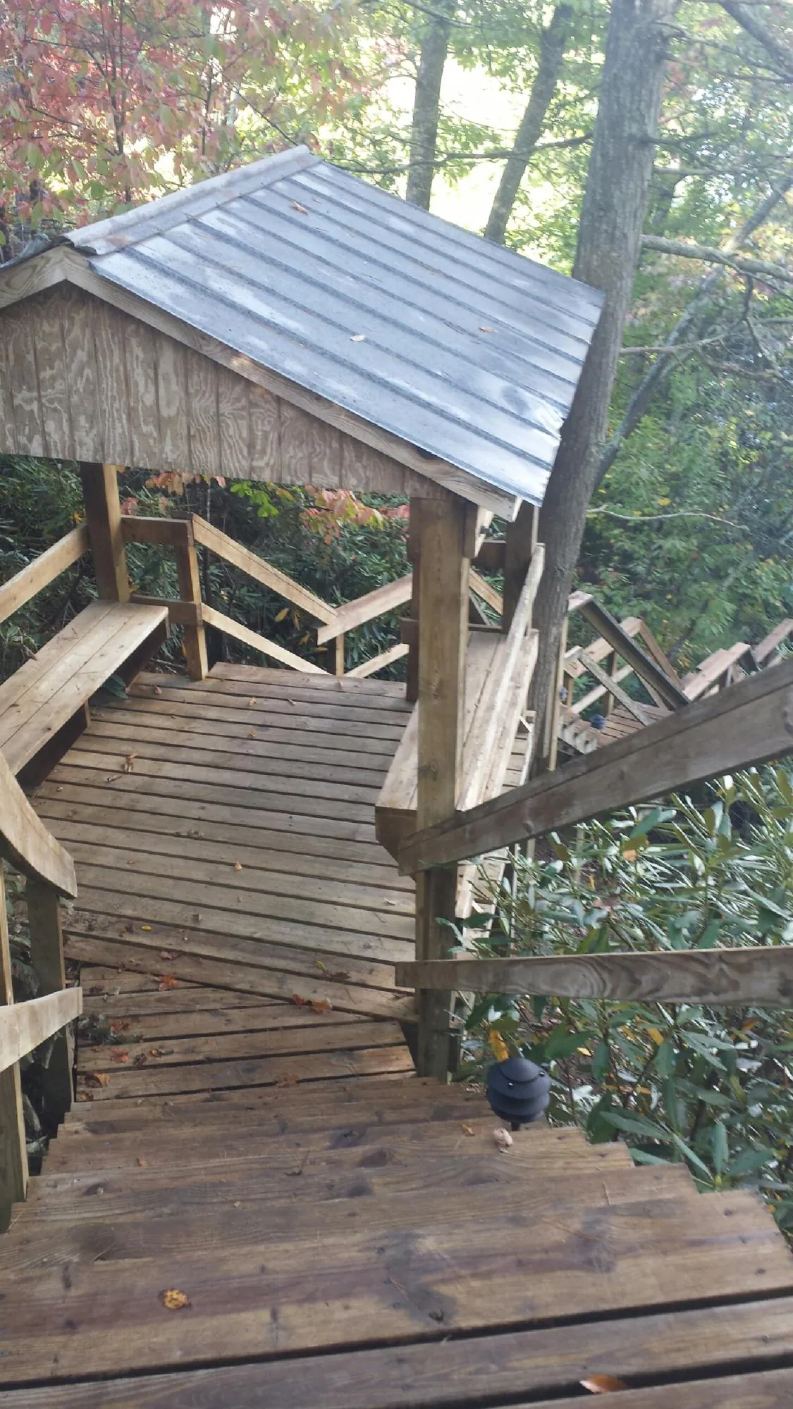 Metal roofed shelter over wooden steps on a wooded walkway — Skylight Repair & Installation work by our crew in Felt