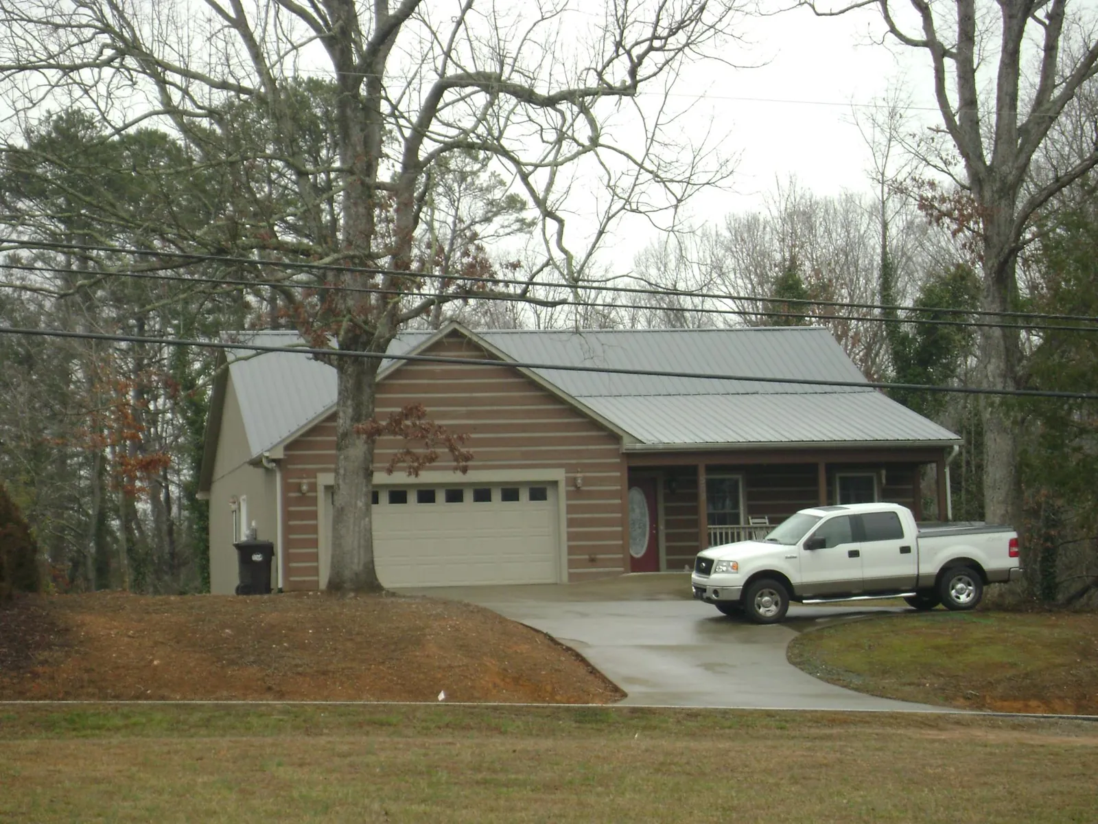 Gray metal roof on a log sided house with an attached two car garage in Felt